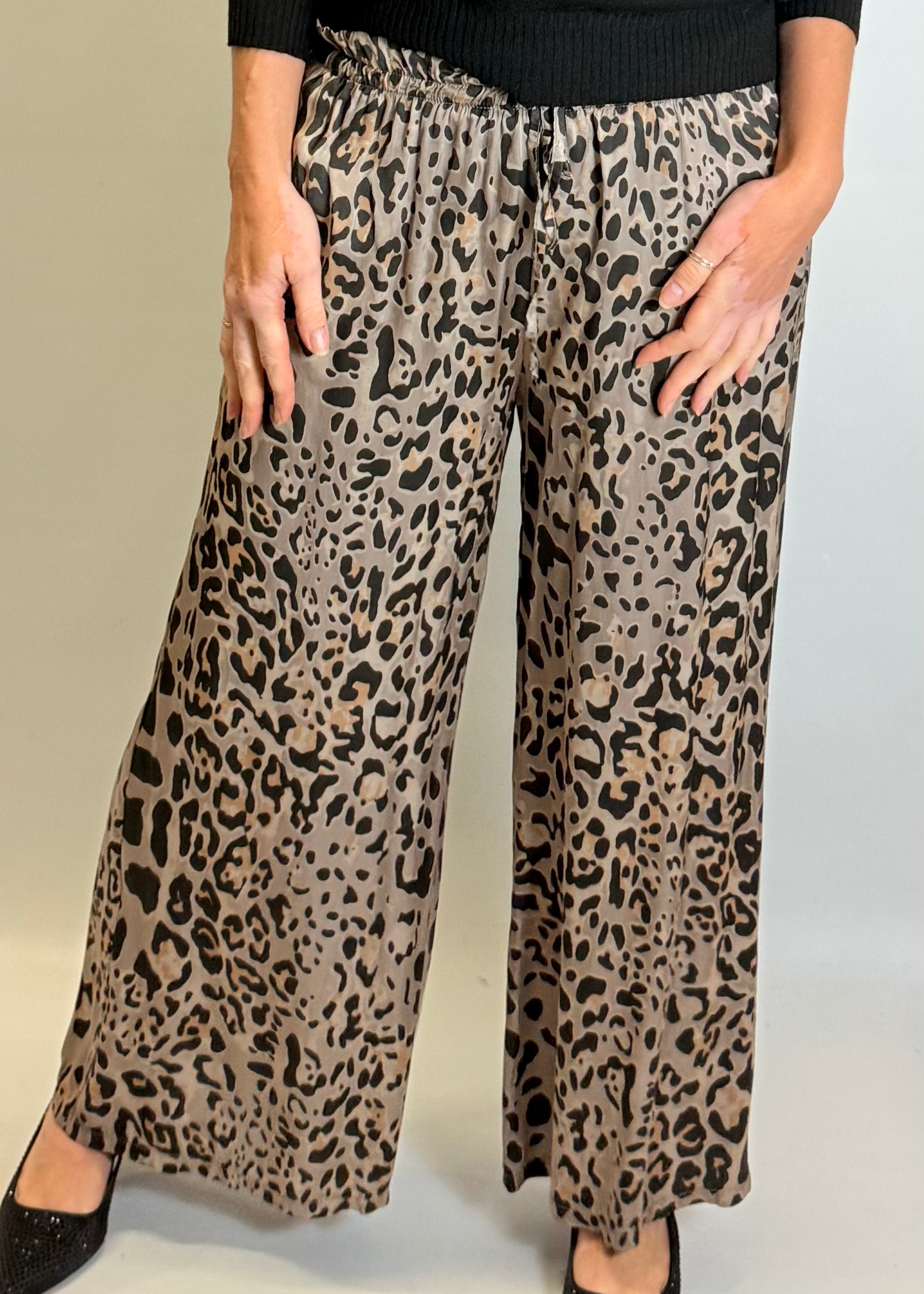 Leopard print pants worn by a person on a plain background