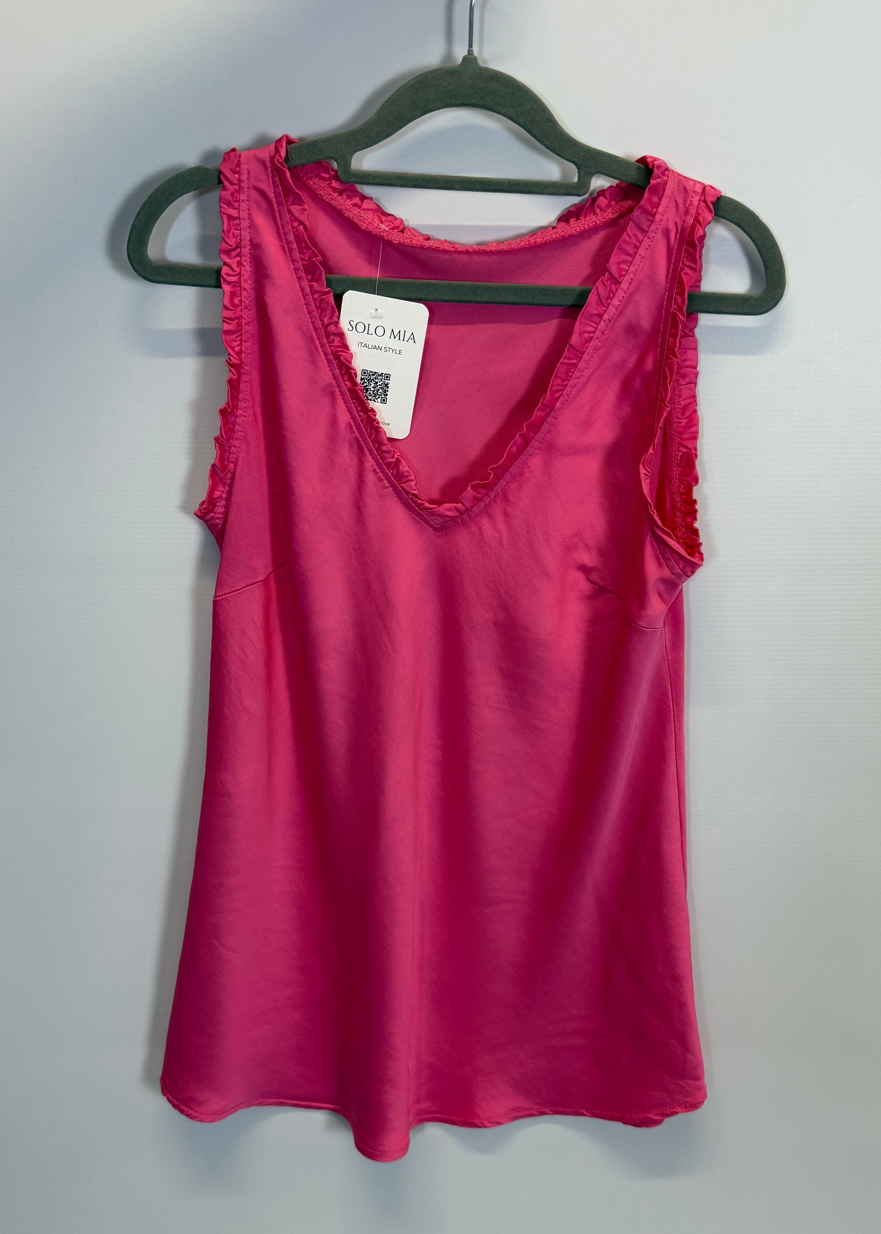 Pink dress on a hanger against a gray background