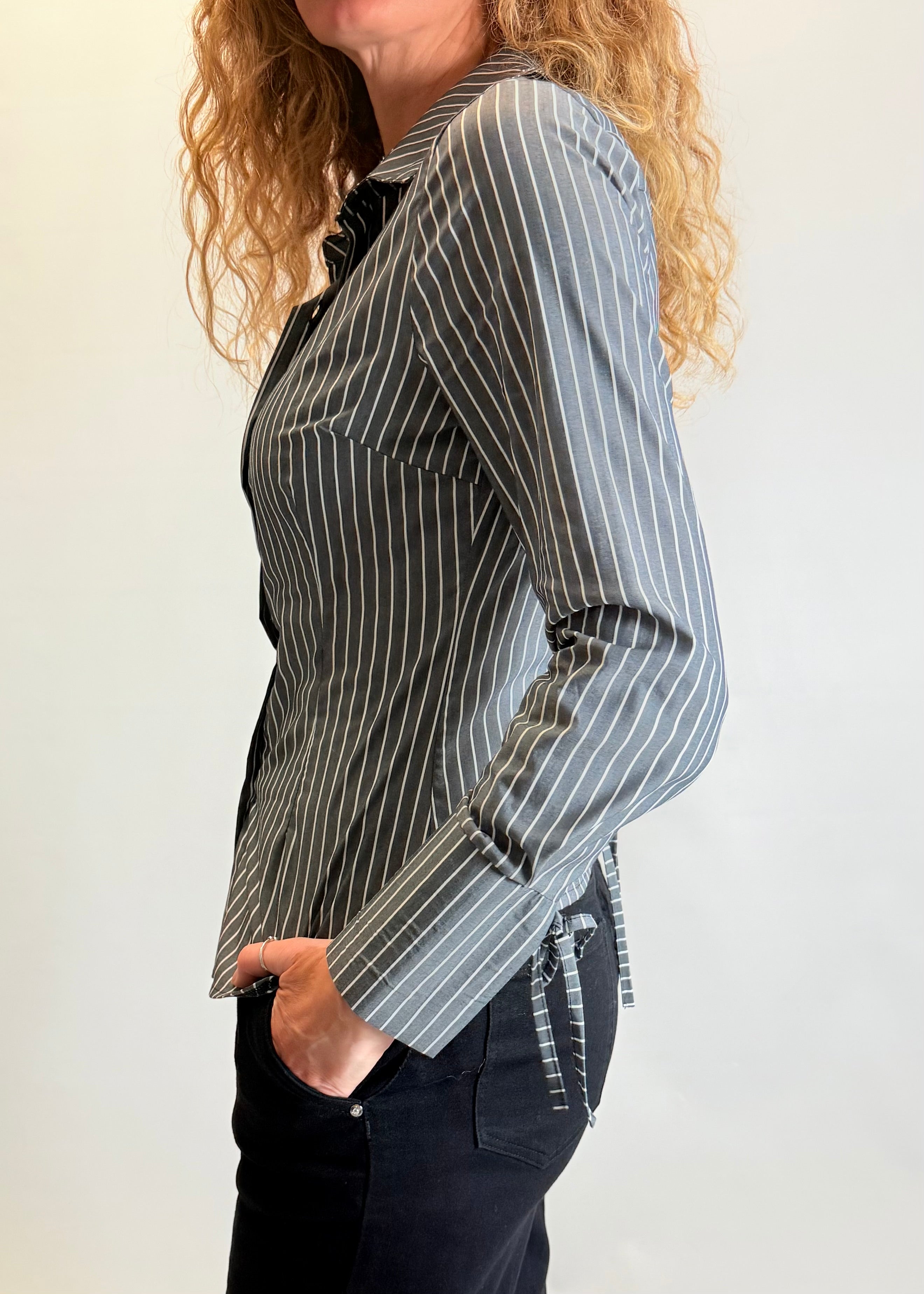 Person wearing a black and white striped shirt with a plain background