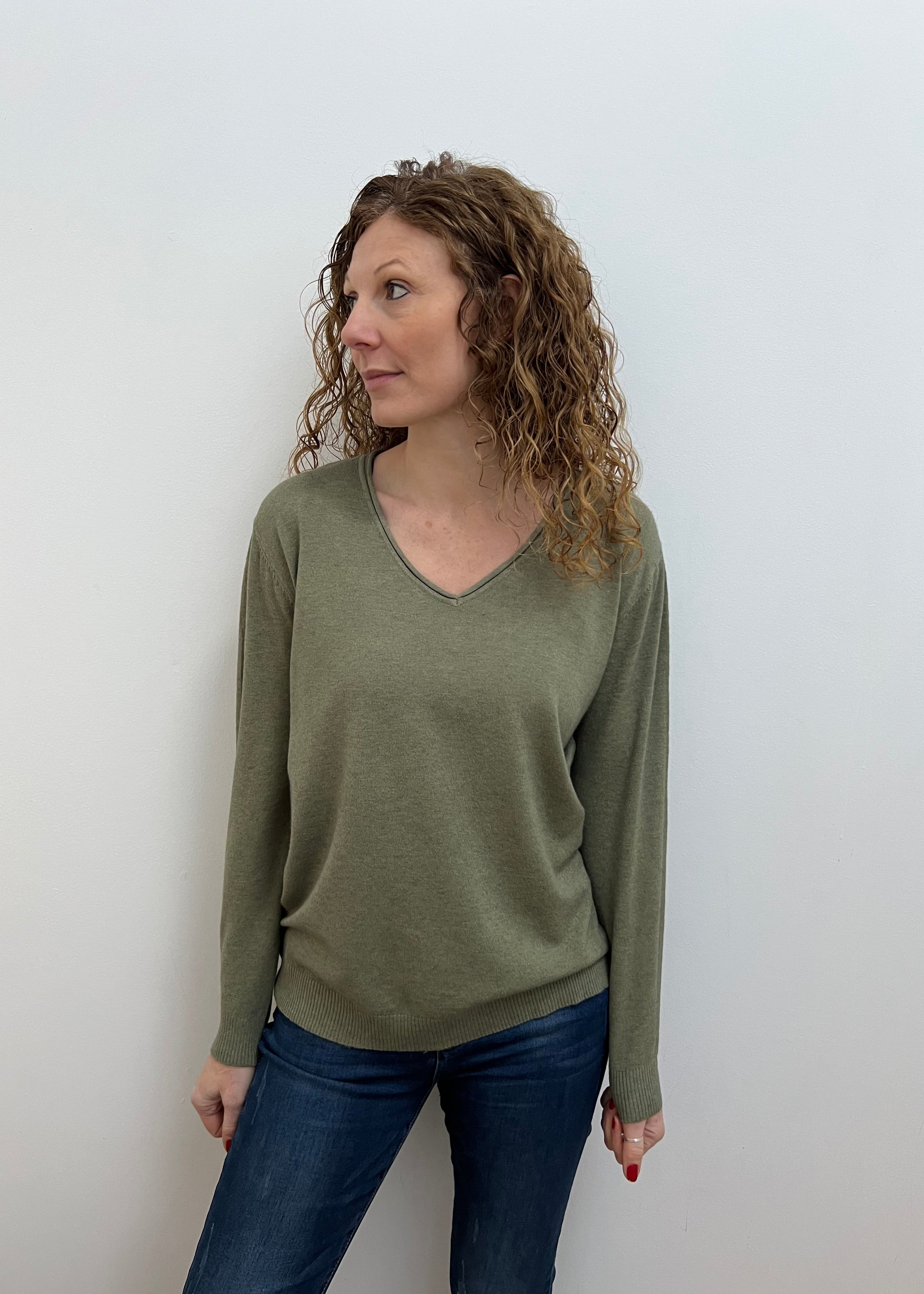 Woman wearing a green V-neck jumper