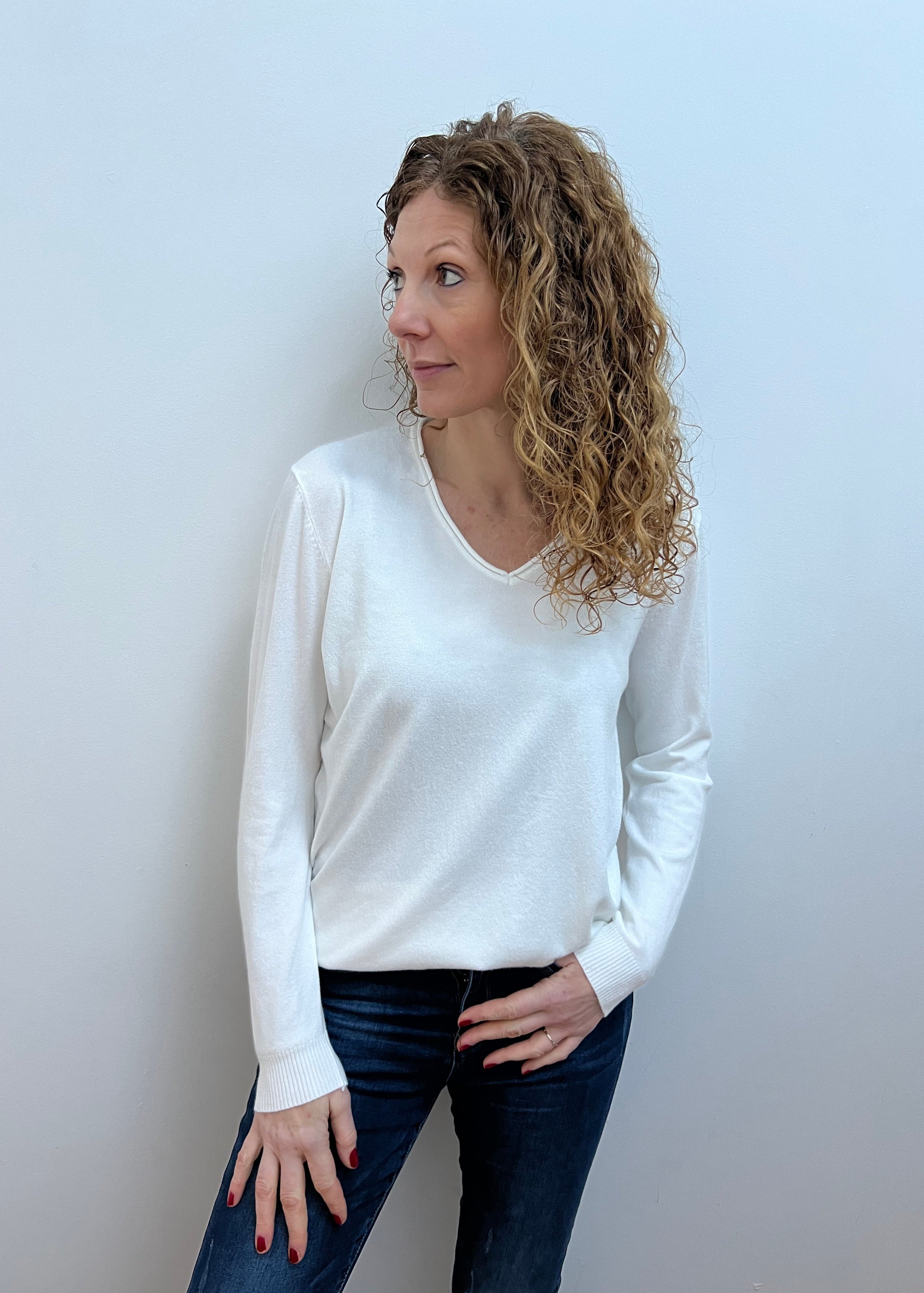 Woman wearing a white V-neck jumper