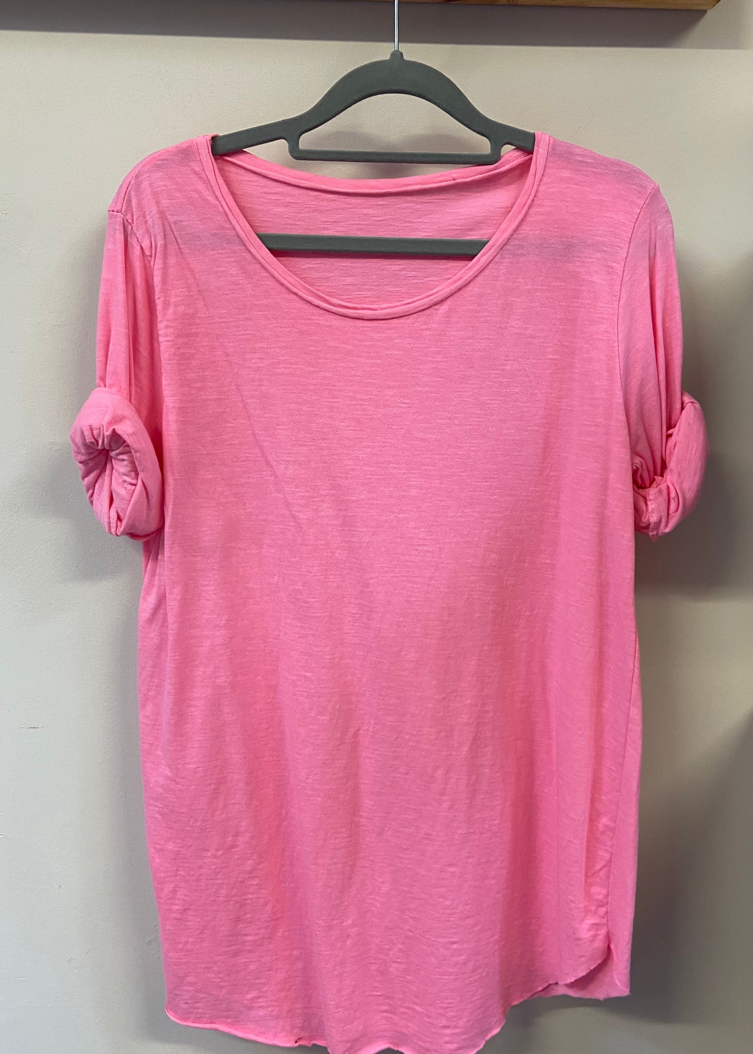 A woman wearing a light blue, long-sleeved cotton top with curved raw edges, in a loose fit style.