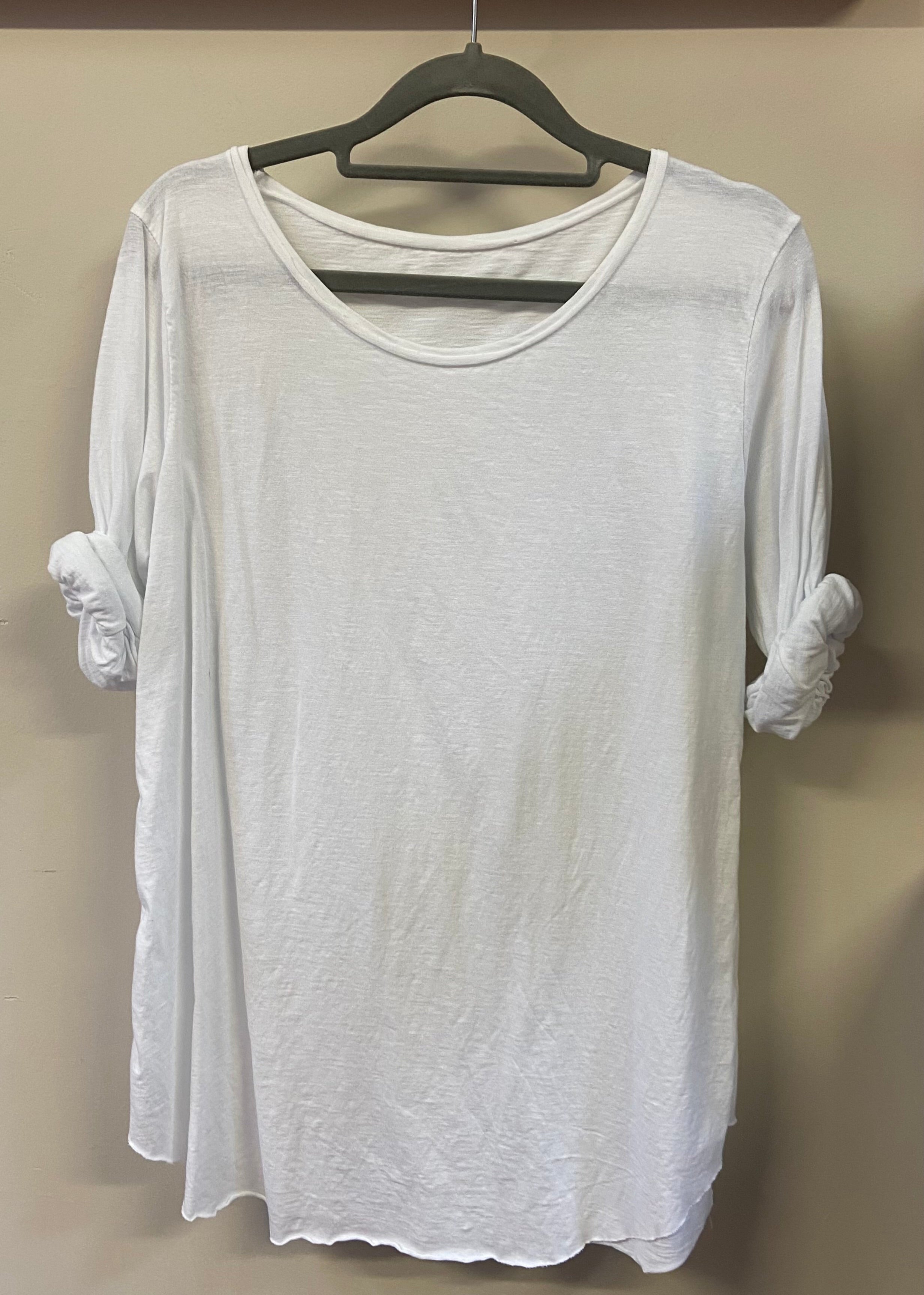 A woman wearing a light blue, long-sleeved cotton top with curved raw edges, in a loose fit style.