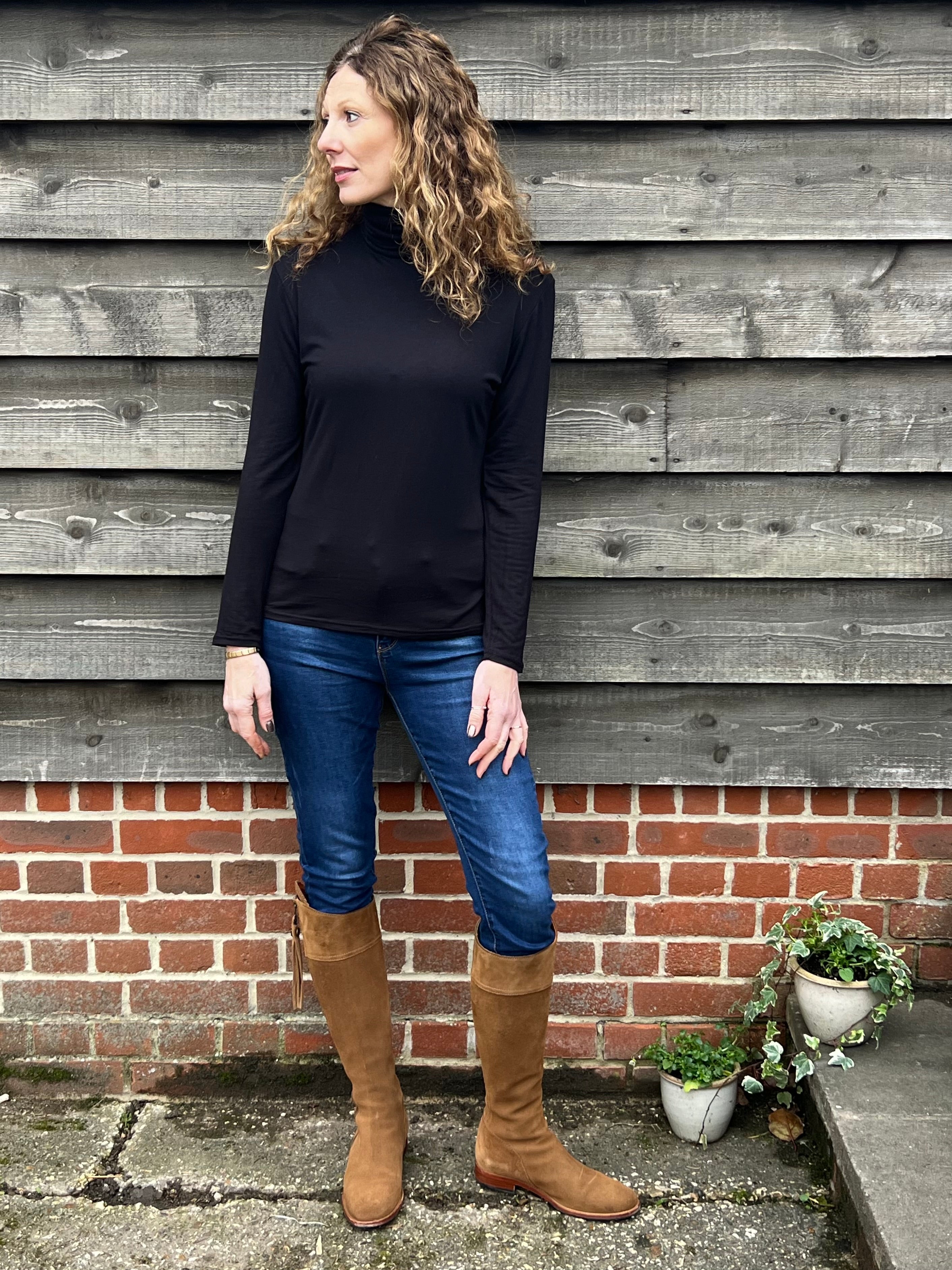 Woman wearing a black strati turtle neck top