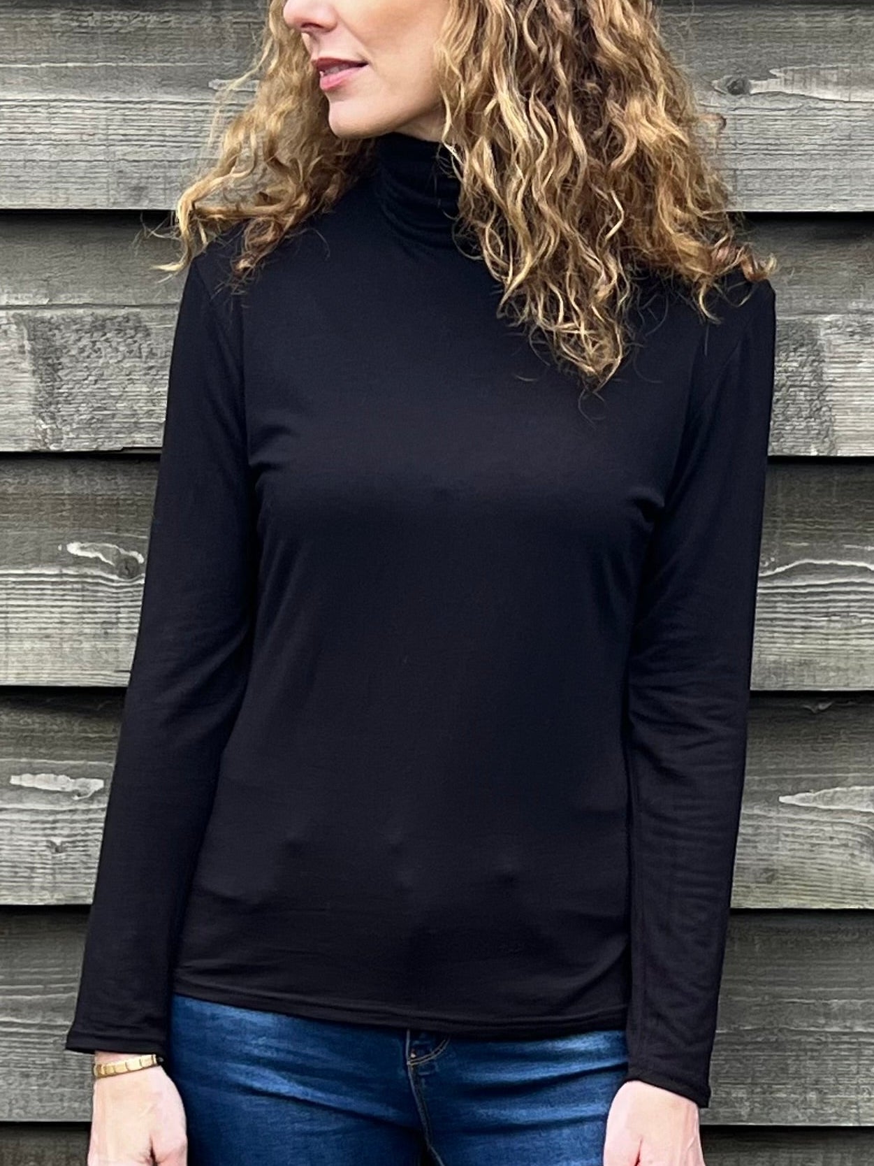 Woman wearing a black strati turtle neck top