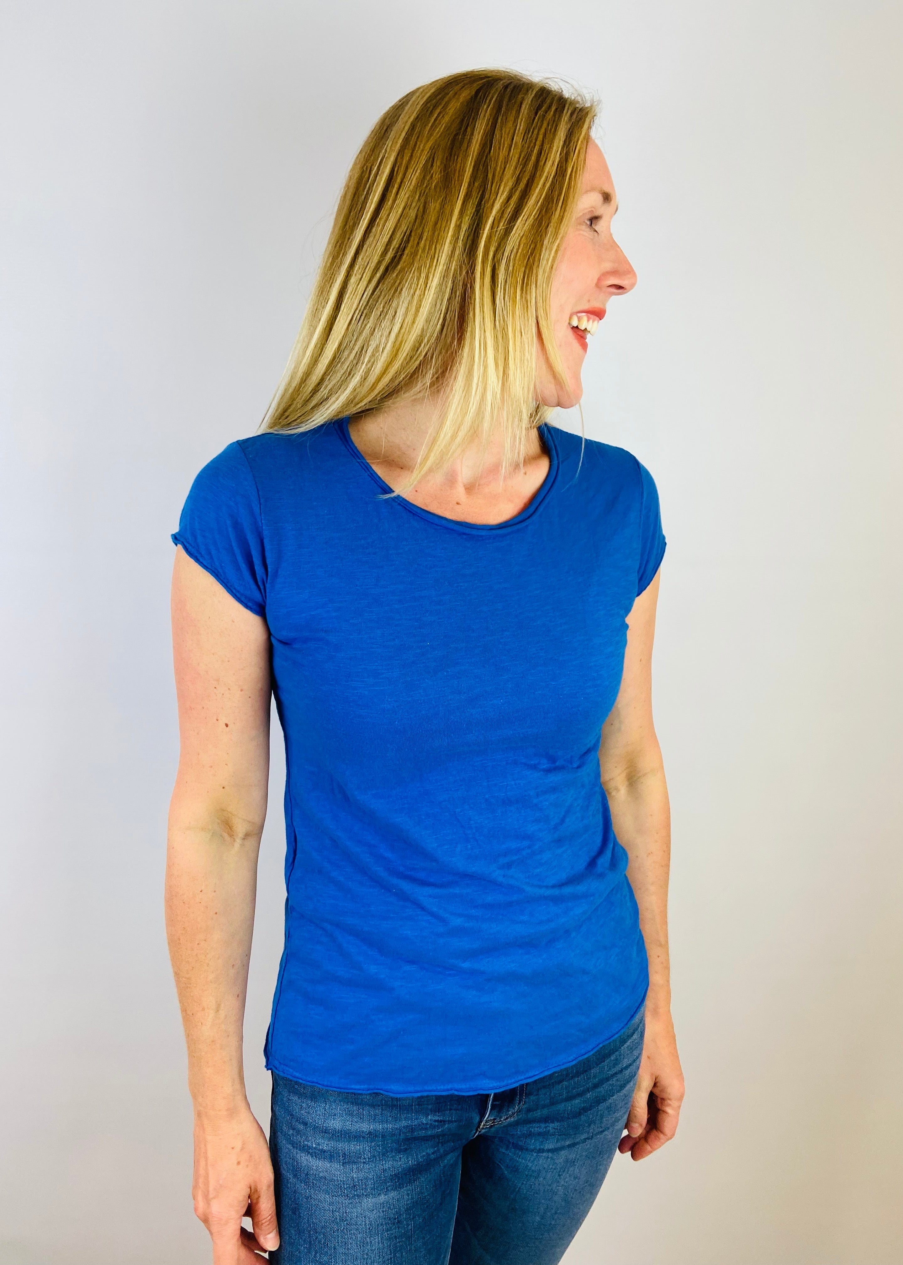 Woman wearing a blue t-shirt against a plain background
